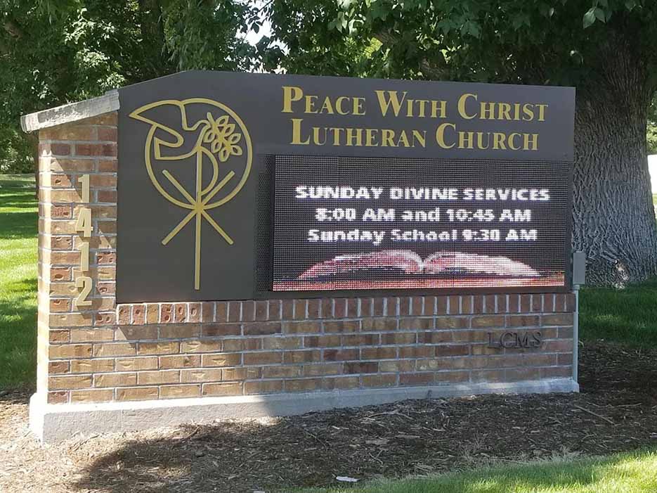 Peace With Christ Lutheran Church front sign showing logo and Sunday service times | Fort Collins, CO