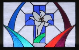 Stained glass window featuring cross and Easter lily
