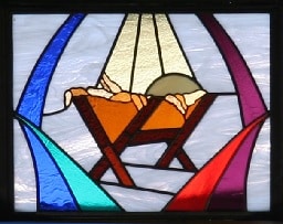 Stained glass window showing the Nativity manger