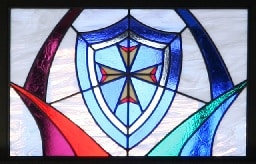 Stained glass window featuring shield of faith with cross